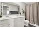 Well-lit bathroom featuring double sinks, white cabinetry, and a shower with a neutral-toned curtain at 8148 Ebaugh Dr, Camby, IN 46113