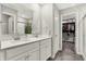 Bathroom featuring double sink vanity, white cabinets, a framed mirror, and a walk in closet at 8148 Ebaugh Dr, Camby, IN 46113