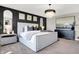 Luxurious main bedroom with a decorative chandelier, dark accent wall, and soft, neutral tones at 8148 Ebaugh Dr, Camby, IN 46113