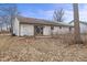 Overgrown backyard with grass and brown siding on the home at 817 Delray Dr, Indianapolis, IN 46241