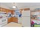 Kitchen featuring appliances and wood cabinetry; window overlooks backyard at 817 Delray Dr, Indianapolis, IN 46241