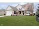 Beautiful two-story home with manicured lawn, brick and vinyl siding, an attached two car garage and a covered entryway at 8654 Arailia Dr, Plainfield, IN 46168