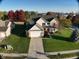 Charming two-story home with a two-car garage, well-maintained lawn, and mature trees providing shade at 8654 Arailia Dr, Plainfield, IN 46168