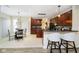 Open-concept kitchen featuring a breakfast bar, pendant lighting, and dark wood cabinetry at 8654 Arailia Dr, Plainfield, IN 46168