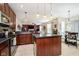 Modern kitchen with stainless steel appliances, dark wood cabinets, and an island with pendant lighting at 8654 Arailia Dr, Plainfield, IN 46168