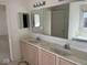 Bathroom vanity with double sinks, large mirror and light fixture with view to tub/shower combo at 9107 Tenor Way, Indianapolis, IN 46231