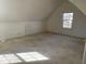 Empty carpeted room with sloped ceilings and a single window at 9107 Tenor Way, Indianapolis, IN 46231