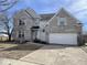 Two-story home with a front-facing garage and neutral colored brick facade at 9107 Tenor Way, Indianapolis, IN 46231