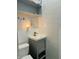 Small bathroom with tiled walls, a gray vanity, and a toilet at 945 N Ewing St, Indianapolis, IN 46201