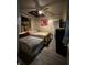 Bedroom with wood-paneled walls, featuring two beds, a ceiling fan, and dresser at 945 N Ewing St, Indianapolis, IN 46201