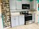Kitchen with gray cabinetry, stainless steel appliances, and unique stone wall at 945 N Ewing St, Indianapolis, IN 46201