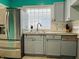 Kitchen featuring gray cabinets, stainless steel refrigerator, and glass block window at 945 N Ewing St, Indianapolis, IN 46201
