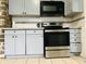 Kitchen showcasing gray cabinets, stainless steel range, and charming tile backsplash at 945 N Ewing St, Indianapolis, IN 46201