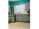 Kitchen featuring stainless steel refrigerator, updated cabinets and sink with a brick glass block window at 945 N Ewing St, Indianapolis, IN 46201