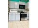 Well-equipped kitchen with sleek black microwave, stainless steel oven and ample storage at 945 N Ewing St, Indianapolis, IN 46201