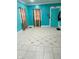 Turquoise living room featuring patterned tile flooring, two windows, and a turquoise door at 945 N Ewing St, Indianapolis, IN 46201
