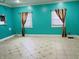 Bright turquoise living room with patterned tile flooring and two windows at 945 N Ewing St, Indianapolis, IN 46201