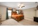 Spacious bedroom featuring tan walls, carpet, a ceiling fan, and a decorative, carved wood bed frame at 9698 W Lantern Ln, Pendleton, IN 46064