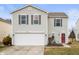 Charming two-story home with a two-car garage, gray siding, dark shutters, and red front door at 9698 W Lantern Ln, Pendleton, IN 46064