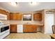 Traditional kitchen with wood cabinets, white appliances, and neutral countertops, offering a functional cooking space at 9698 W Lantern Ln, Pendleton, IN 46064