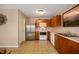 Bright kitchen featuring stainless steel refrigerator, wood cabinetry, and tile flooring, offering ample space at 9698 W Lantern Ln, Pendleton, IN 46064