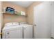 Practical laundry room with a washer, dryer, storage shelf, and beige walls, offering convenience at 9698 W Lantern Ln, Pendleton, IN 46064