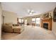 Cozy living room featuring plush carpeting, a ceiling fan, and a fireplace with a decorative mantle at 9698 W Lantern Ln, Pendleton, IN 46064