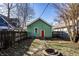 This backyard features a green outbuilding with a red door and a fire pit at 1130 E Bradbury Ave, Indianapolis, IN 46203