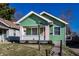 A quaint green house with an orange door, set against a bright blue sky at 1130 E Bradbury Ave, Indianapolis, IN 46203