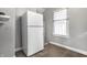 The kitchen featuring a white refrigerator with tile floors and a window at 1130 E Bradbury Ave, Indianapolis, IN 46203