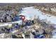Drone shot of a lakeside neighborhood, emphasizing the home's location with a prominent red marker at 11338 Bayhill Way, Indianapolis, IN 46236