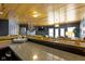 Open basement bar with a dark gray color scheme, hardwood ceiling, and a view of the living area at 11338 Bayhill Way, Indianapolis, IN 46236