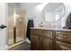 Bathroom featuring a granite vanity top, round mirror, and a glass-enclosed shower at 11338 Bayhill Way, Indianapolis, IN 46236