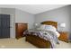 Cozy bedroom with a bed with patterned bedding, gray walls, carpet flooring, and two wooden dressers at 11338 Bayhill Way, Indianapolis, IN 46236