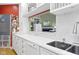 Well-lit kitchen with white cabinets, stainless steel sink, and an open view to the living room at 11338 Bayhill Way, Indianapolis, IN 46236