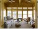 Cozy sunroom with wood-paneled walls, comfortable seating, and views of the lake at 11338 Bayhill Way, Indianapolis, IN 46236