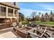 Spacious outdoor patio area with a stone fireplace, comfortable seating, and a lush green lawn at 11573 Bent Tree Ct, Zionsville, IN 46077