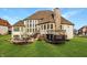 Expansive backyard featuring a stone fireplace with seating area, deck and a trampoline at 11573 Bent Tree Ct, Zionsville, IN 46077