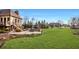 Large, well-maintained backyard with a stone patio, lush lawn, and mature trees offering privacy at 11573 Bent Tree Ct, Zionsville, IN 46077