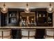 Close up of the basement bar featuring mirrored backsplash, modern lighting, and dark cabinetry at 11573 Bent Tree Ct, Zionsville, IN 46077