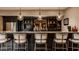 Basement bar featuring modern pendant lighting, granite countertops, and dark cabinetry at 11573 Bent Tree Ct, Zionsville, IN 46077