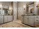 Elegant bathroom featuring double vanities with granite countertops and decorative mirrors and lighting fixtures at 11573 Bent Tree Ct, Zionsville, IN 46077