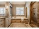 Luxurious bathroom featuring a soaking tub, tiled shower, granite countertops, and custom vanity at 11573 Bent Tree Ct, Zionsville, IN 46077