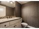 Stylish half-bathroom featuring granite countertop, modern fixtures, and decorative wallpaper at 11573 Bent Tree Ct, Zionsville, IN 46077