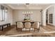 Bright dining room with stylish lighting, a large table set for dining, and views of the outdoors at 11573 Bent Tree Ct, Zionsville, IN 46077