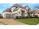 Charming two-story home with a three-car garage, manicured lawn, and stone and siding exterior at 11573 Bent Tree Ct, Zionsville, IN 46077