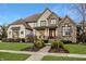 Charming two-story home with stone and painted brick elevation, landscaped front yard, and a covered front porch at 11573 Bent Tree Ct, Zionsville, IN 46077