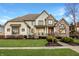 Beautiful two-story home featuring manicured lawn, stone accents, and welcoming covered porch at 11573 Bent Tree Ct, Zionsville, IN 46077