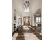 Bright foyer featuring hardwood floors, large windows, statement lighting and elegant staircase at 11573 Bent Tree Ct, Zionsville, IN 46077