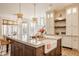Bright kitchen with an island, farmhouse sink, pendant lights, and seating at 11573 Bent Tree Ct, Zionsville, IN 46077